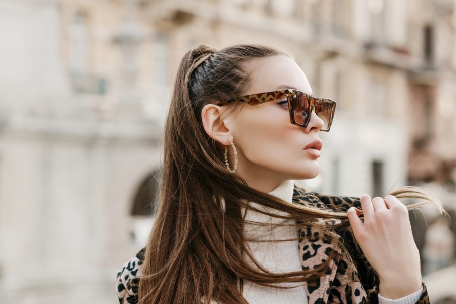 Stylish woman wearing polarized sunglasses outdoors, showcasing glare reduction, eye comfort, and enhanced visual clarity benefits - are polarized sunglasses worth it