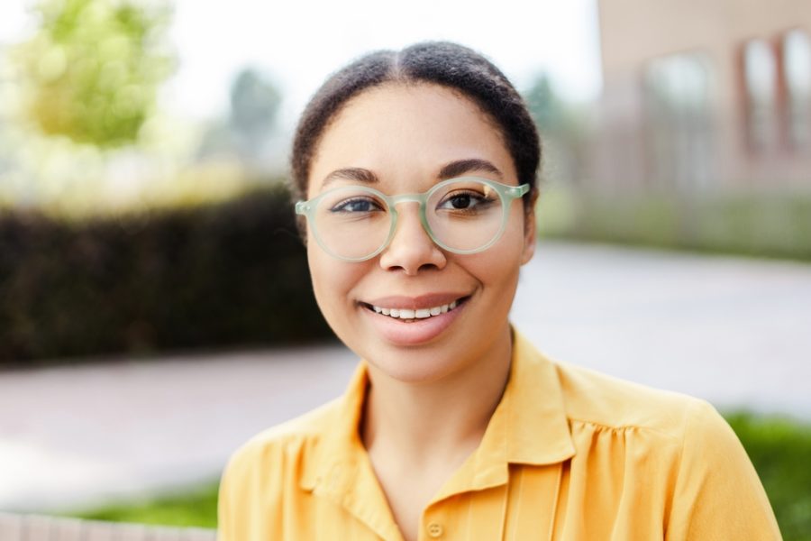 Woman wearing modern eyeglasses outdoors, representing vision correction updates and signs of a significant change in eyeglass prescription - what is a significant change in eyeglass prescription